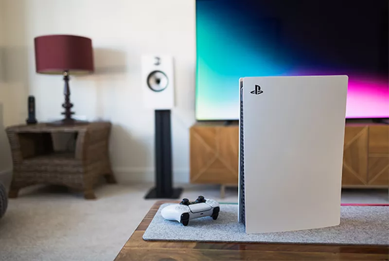 a white playstation 5 console sitting on a table in a living room in front of a tv